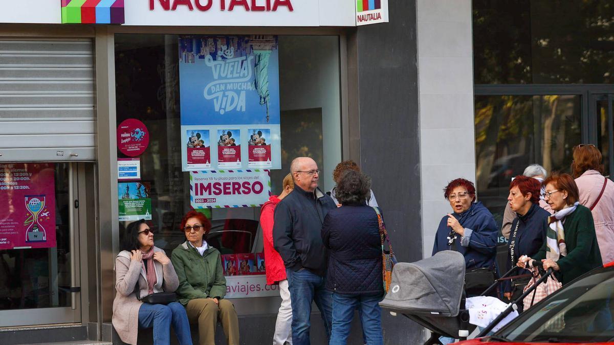 Personas mayores esperan en una agencia para reservar sus destinos del Imserso esta mañana en València.