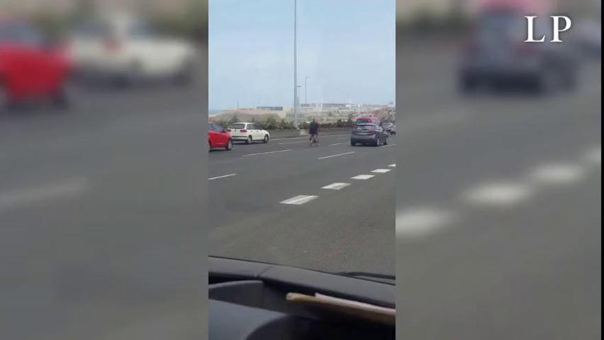 Una mujer maneja su bibicleta en el centro de la autopista