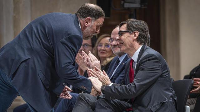 El president de la Generalitat, Salvador Illa, i el president d’Esquerra Republicana de Catalunya, Oriol Junqueras, es donen la mà en un acte per l’any Irla, al març. | MANU MITRU