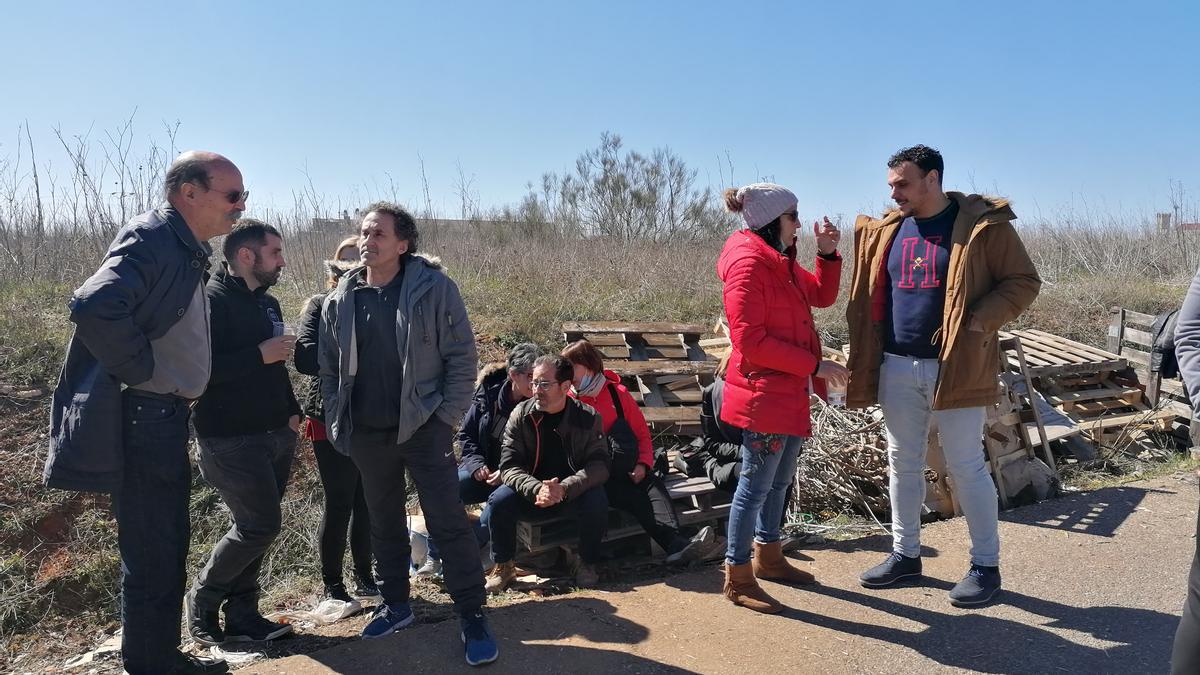 Del Bien (primero derecha) conversa con trabajadores en las puertas de la fábrica