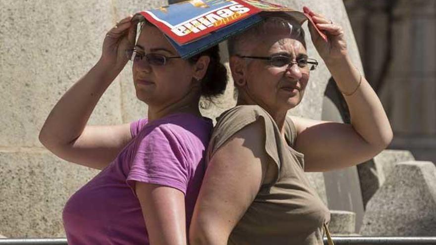 Dos turistas se protegen del calor en Sevilla.