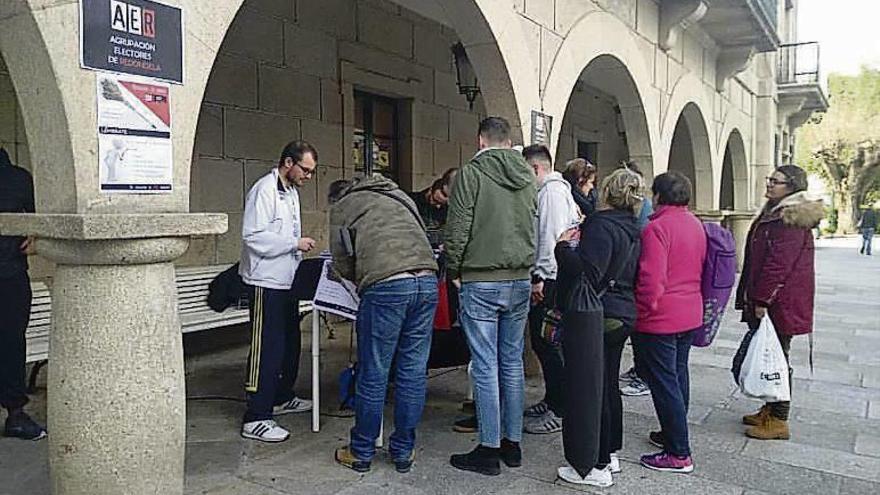 Unas personas hacen cola para firmar a AER en Redondela. // FdV