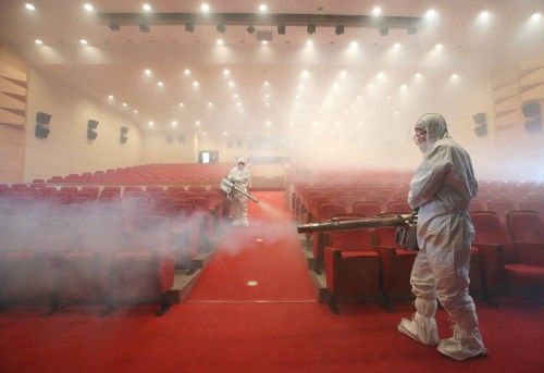 Workers in full protective gear disinfect an art hall in Seoul