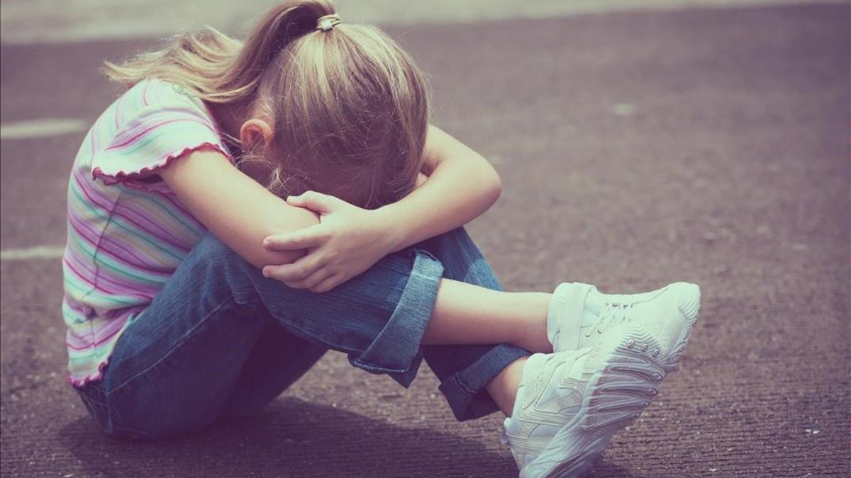 Una niña llora en el suelo