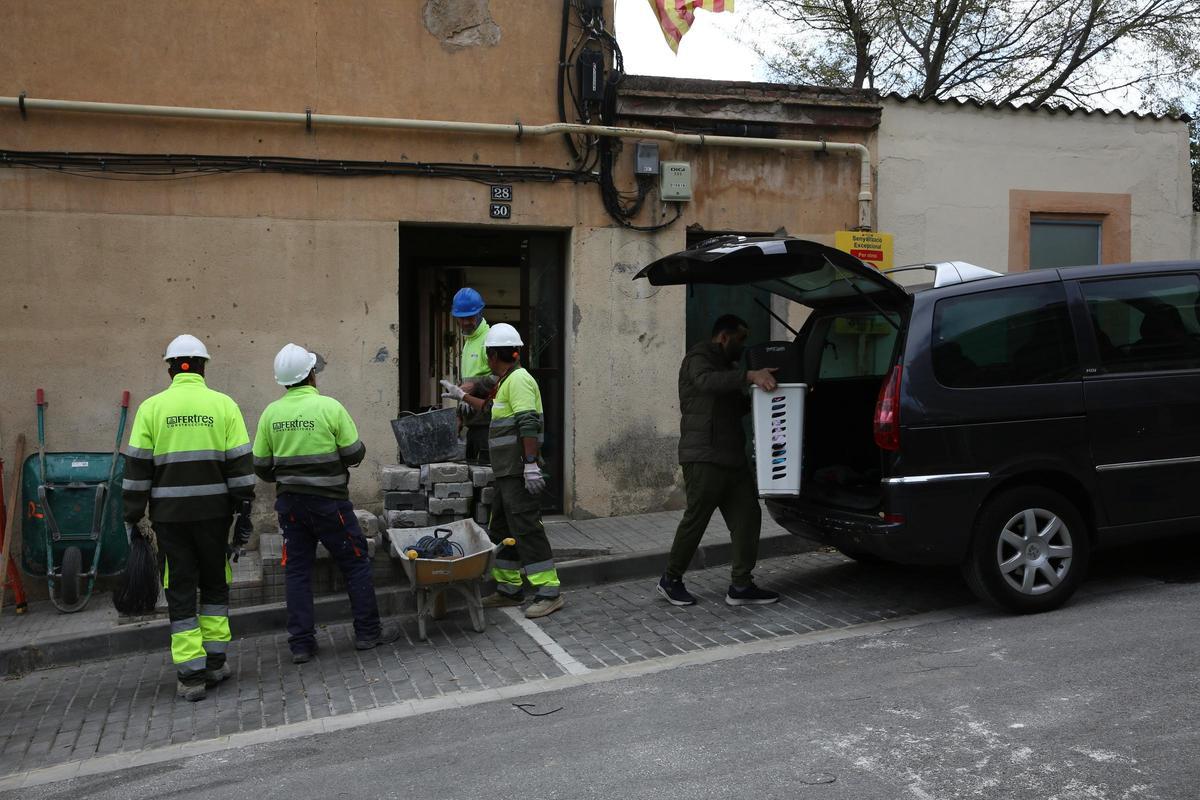 Operarios trabajando en el aseguramiento de la estructura del edificio 'El Barco' de Esplugues, mientras los vecinos retiran sus pertenencias