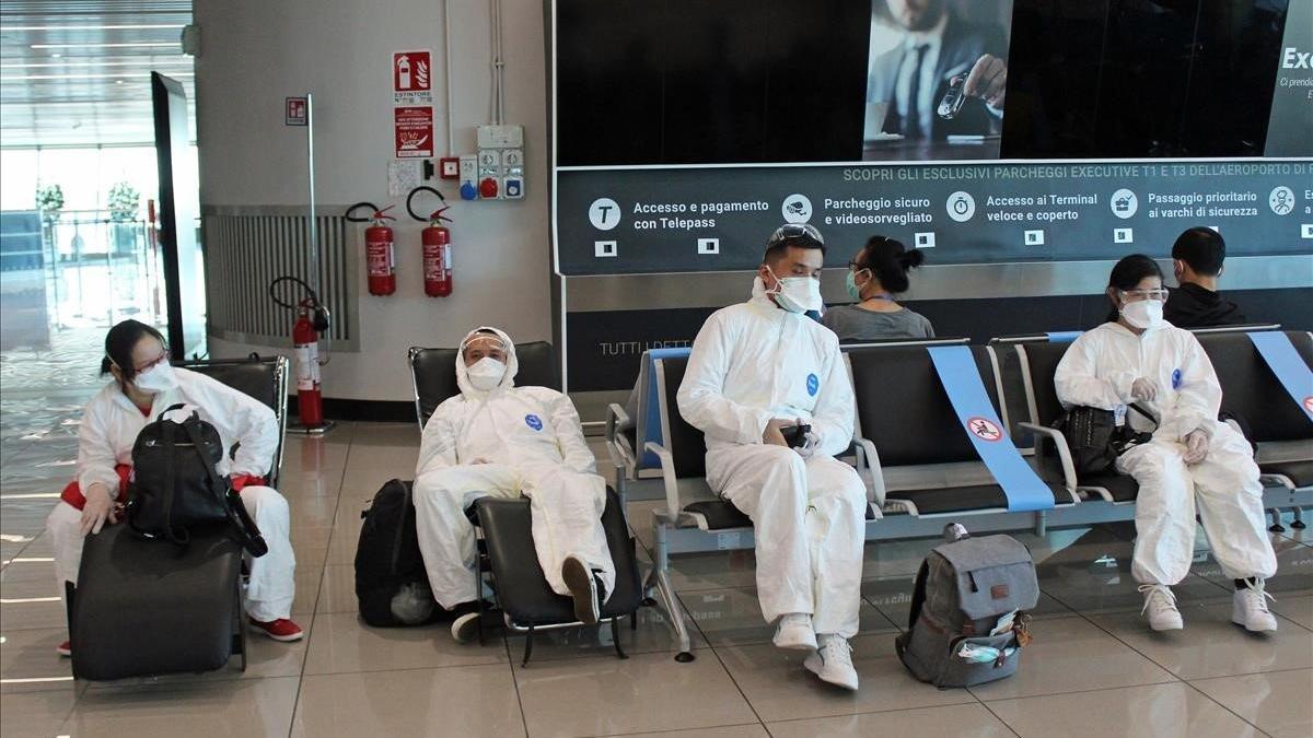 Medidas de protección de un grupo de pasajeros en el aeropuerto romano de Fiumicino.