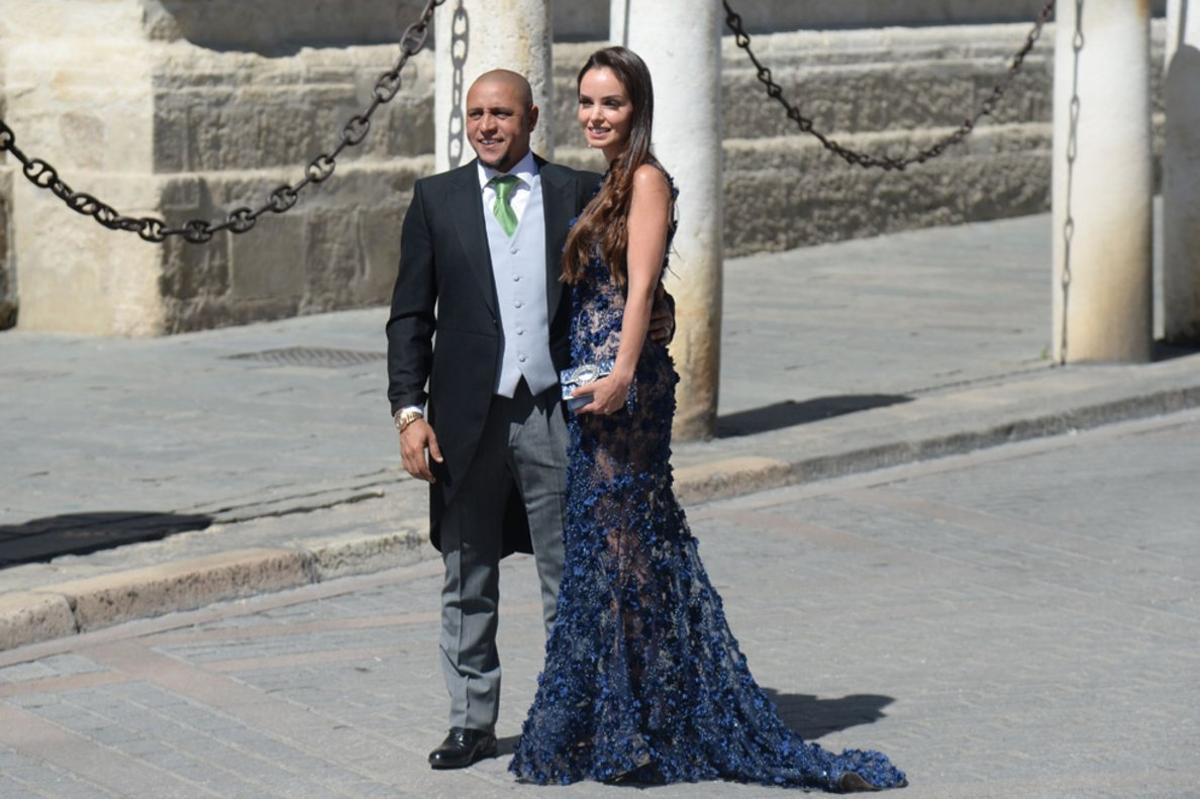 El exfutbolista brasileño Roberto Carlos y su pareja a su llegada a la Catedral de Sevilla para asistir este sábado a la boda de la presentadora Pilar Rubio y el futbolista Sergio Ramos