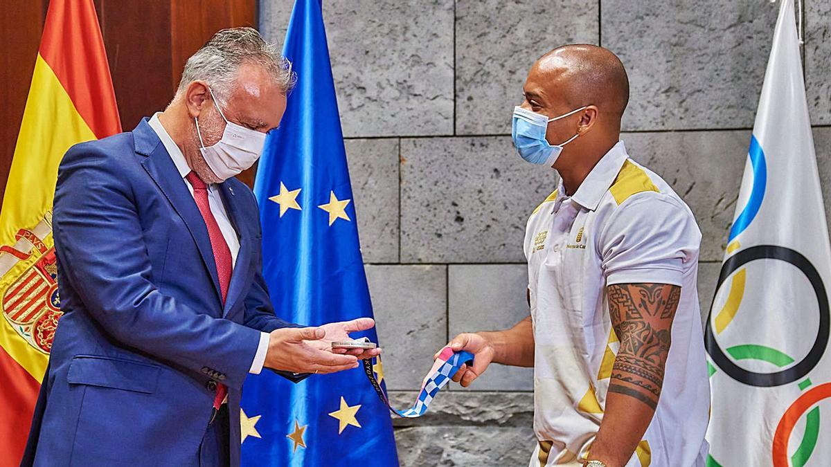 El gimnasta Ray Zapata muestra la medalla de plata al presidente del Ejecutivo canario Ángel Víctor Torres, ayer, durante la recepción en el sede del Gobierno.  | | E. PRESS 