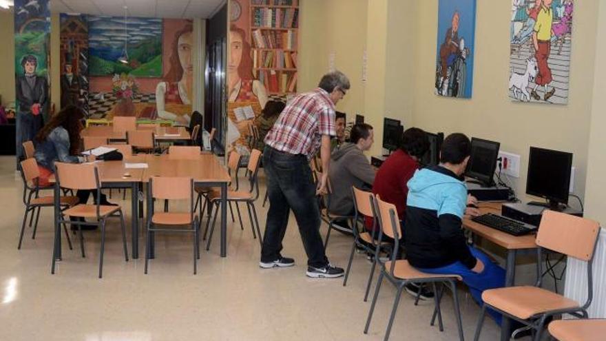 Un profesor del IES Torrente Ballester imparte clase en la biblioteca, lo que permite mantener la instalación abierta         para uso de otros estudiantes.