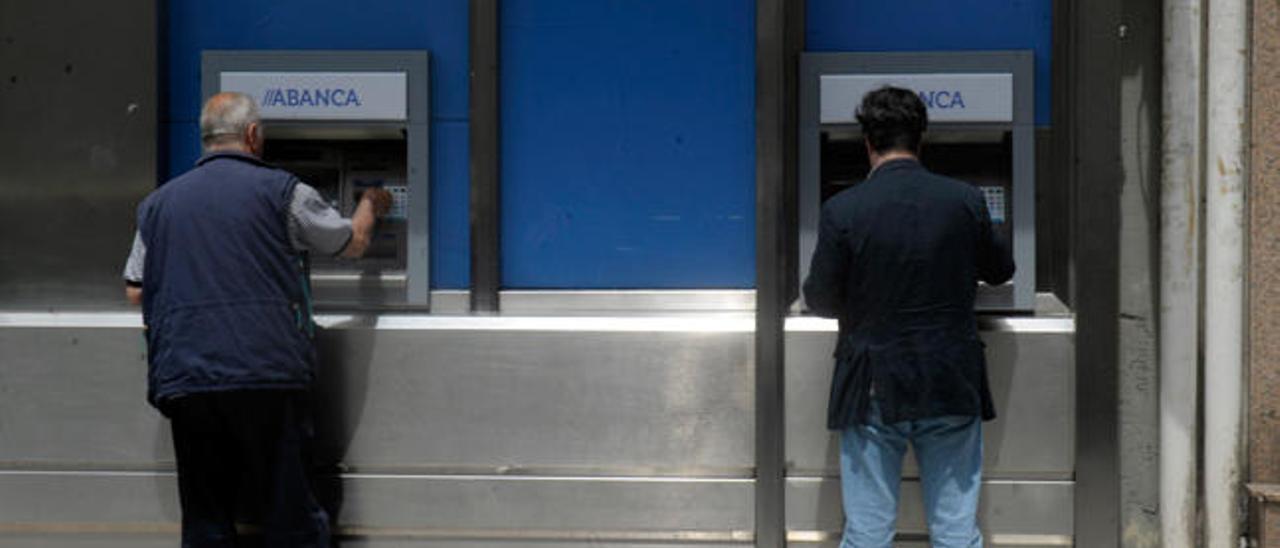Dos clientes de Abanca retiran dinero en A Coruña // Victor Echave