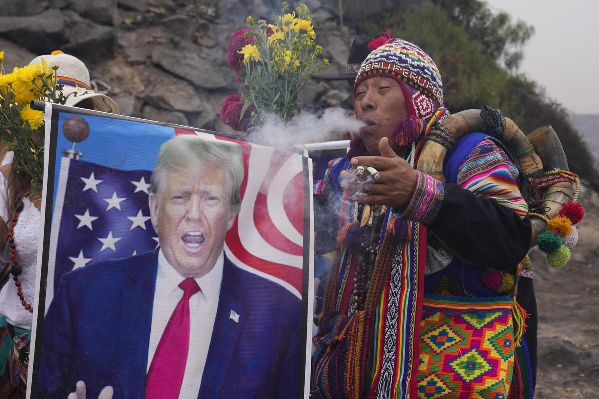 Un chamán echa humo sobre una imagen de Donald Trump en un ritual para realizar predicciones para 2025 en Lima, Perú, el pasado 27 de diciembre.