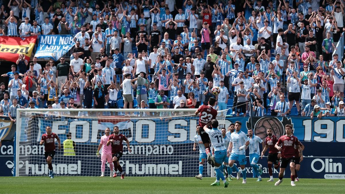 La afición del Málaga CF observa el encuentro ante el AD Mérida.