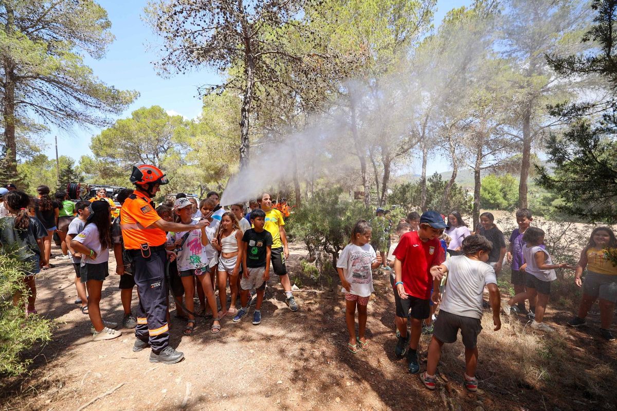 Los niños se refrescan bajo la manguera.