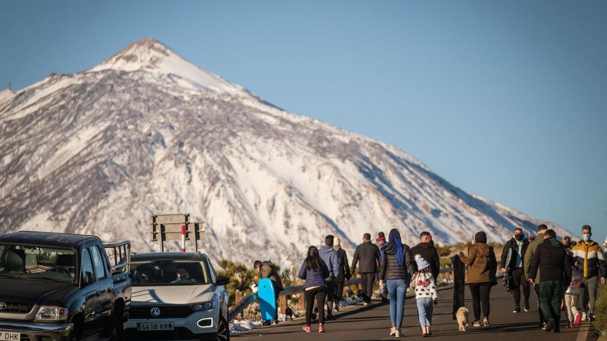 Personas y vehículos en el interior del Parque Nacional del Teide en un día de nevada.