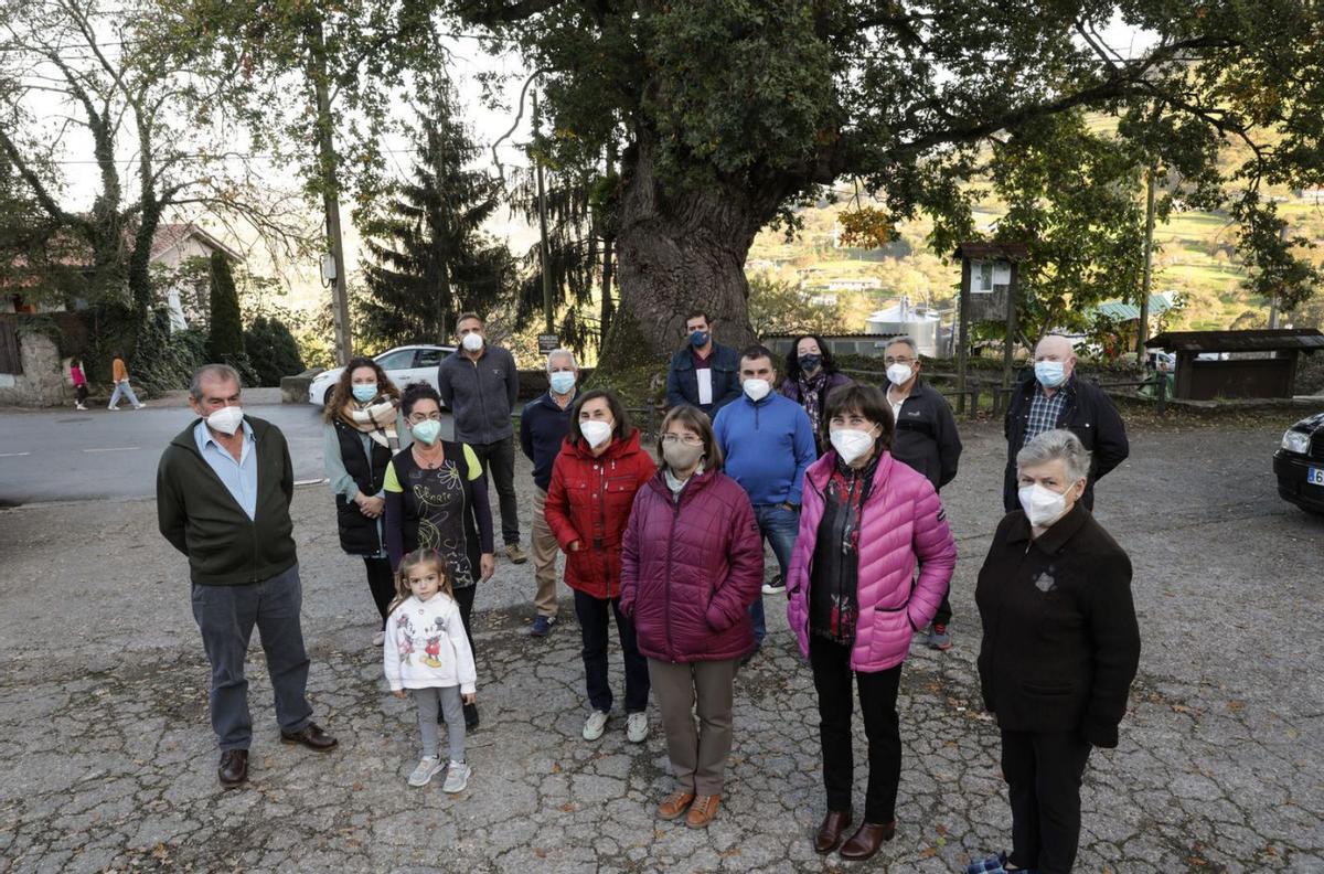 A la izquierda, Antonio Piñera, presidente vecinal de Lavandera, con un grupo de vecinos de la parroquia, ayer, en el campo de la iglesia. | Juan Plaza