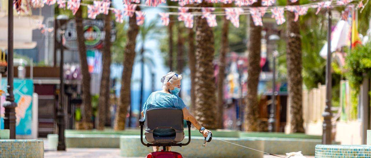 Una turistas pasea por la desolada zona giri de Benidorm