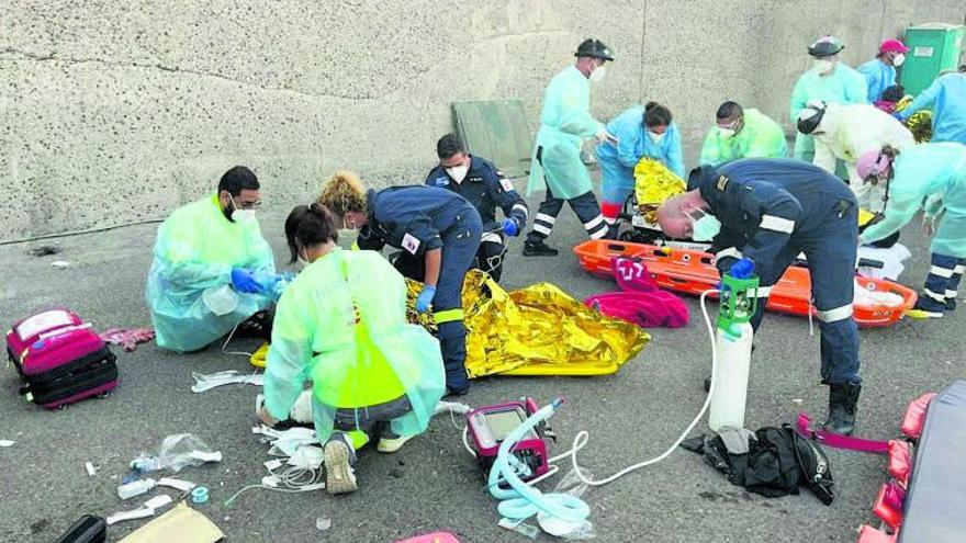 Personal sanitario atiende a los migrantes que fueron rescatados en mal estado de salud al sur de Arguineguín, ayer, en el muelle del puerto de Mogán.