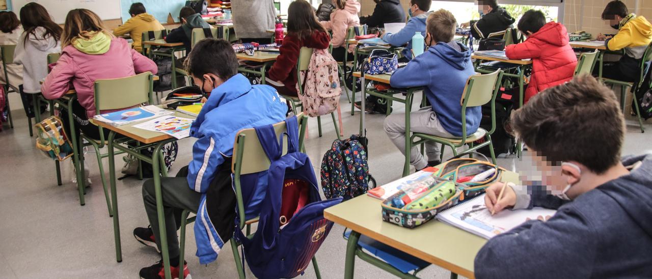 Alumnos dan clase con mascarilla en un colegio de la provincia