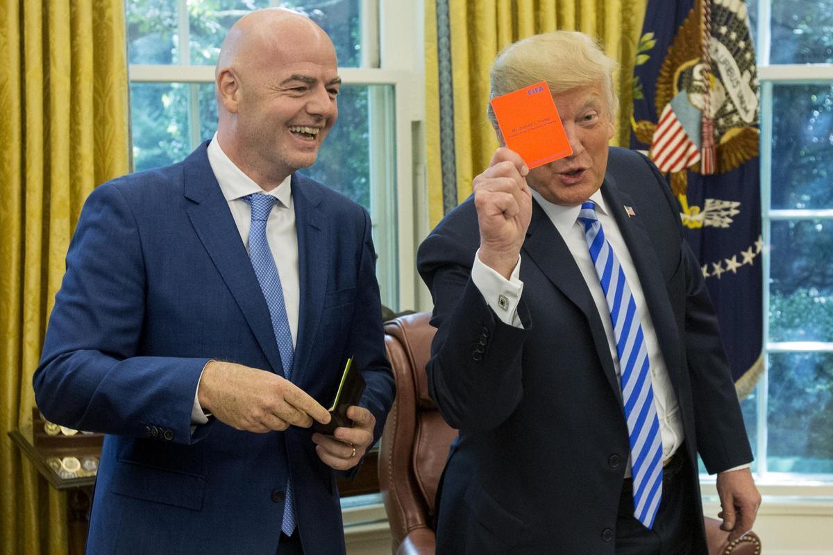El presidente de los Estados Unidos, Donald Trump, sostiene una tarjeta roja que tiene su nombre escrito, junto al presidente de la FIFA, Gianni Infantino, en la Oficina Oval de la Casa Blanca, en Washington, DC