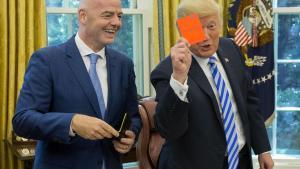 El presidente de los Estados Unidos, Donald Trump, sostiene una tarjeta roja que tiene su nombre escrito, junto al presidente de la FIFA, Gianni Infantino, en la Oficina Oval de la Casa Blanca, en Washington, DC