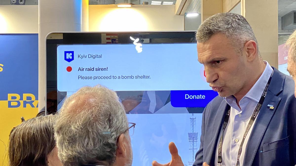 El alcalde de Kiev, en el estand de su ciudad en el congreso Smart City. En la pantalla, el mensaje que recibe la población cuando se produce un ataque ruso sobre la ciudad