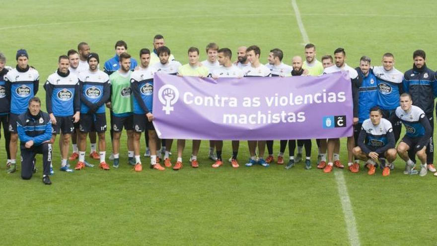 Jugadores del Deportivo sostienen un cartel contra la violencia machista.