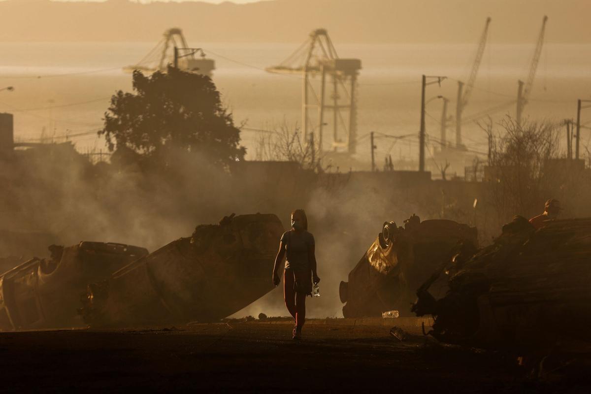 Una mujer camina entre autos quemados después de un incendio forestal en Concepción, Chile, el 18 de enero de 2026.