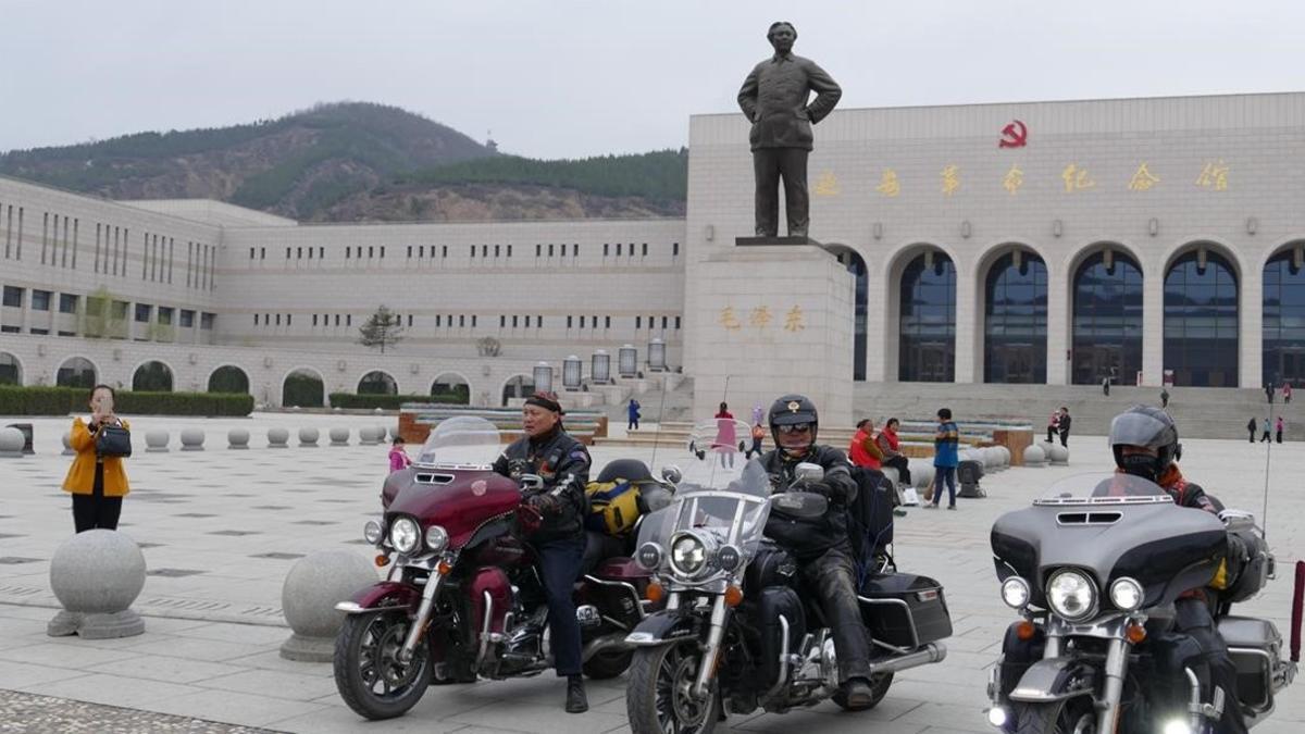 Chinos en Harley Davidson frente estatua de Mao en la entrada del Museo de la Revolucion en Yanan.