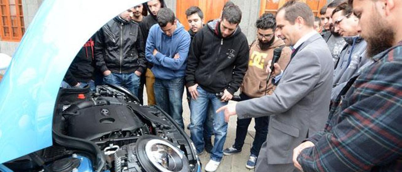 Los alumnos de Automoción escuchan los detalles técnicos del nuevo Mini en la plaza de la Constitución.