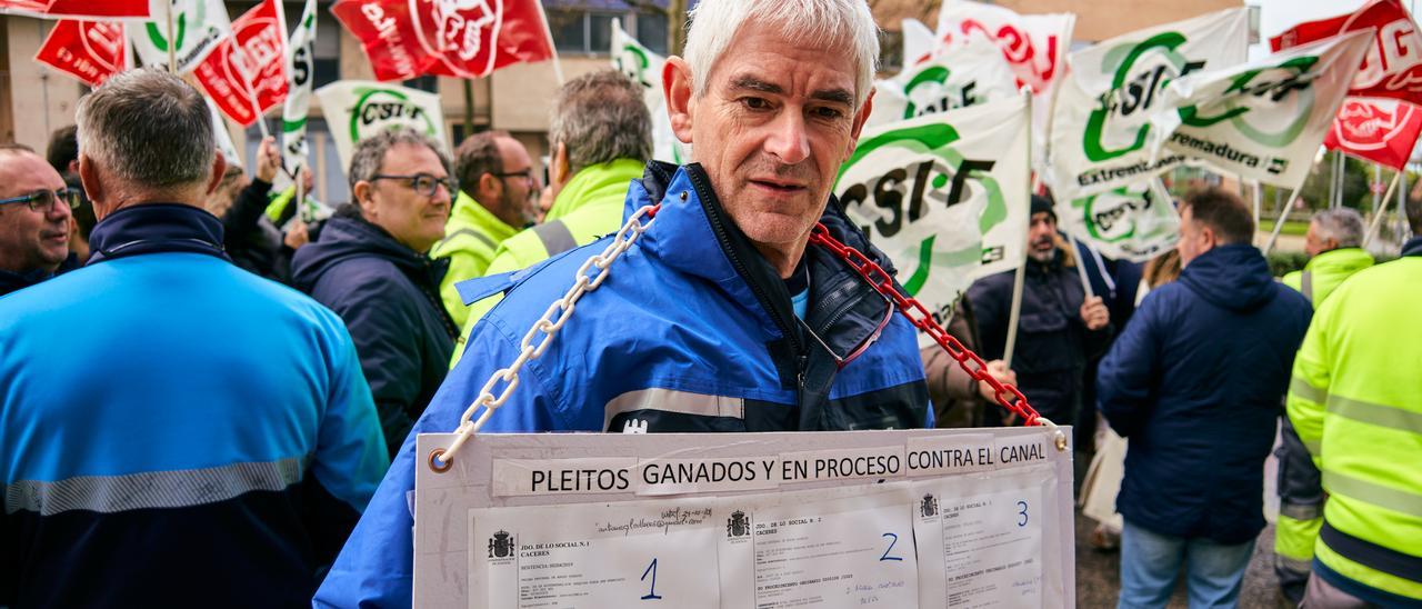 Un manifestante porta una pancarta con las demandas interpuestas a Canal de Isabel II en Cáceres, que la directiva pide ahora retirar para avanzar en las negociaciones.