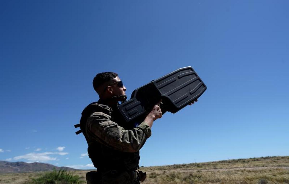 Un legionario apunta al cielo con una escopeta electrónica antidrón.