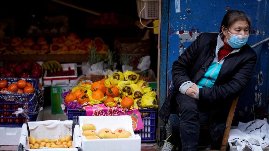 Una mujer en un puesto de fruta en Wuhan.