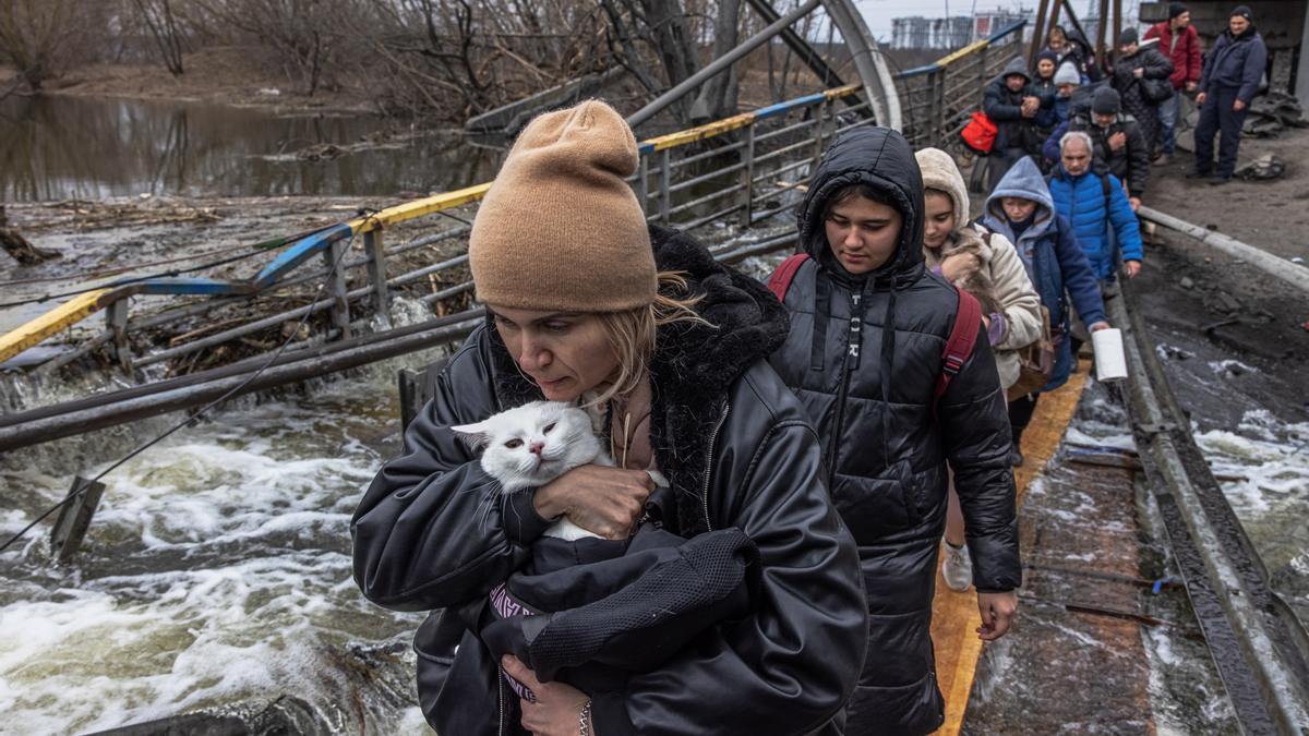 Varias mujeres cruzan un puente destruido en Irpin.