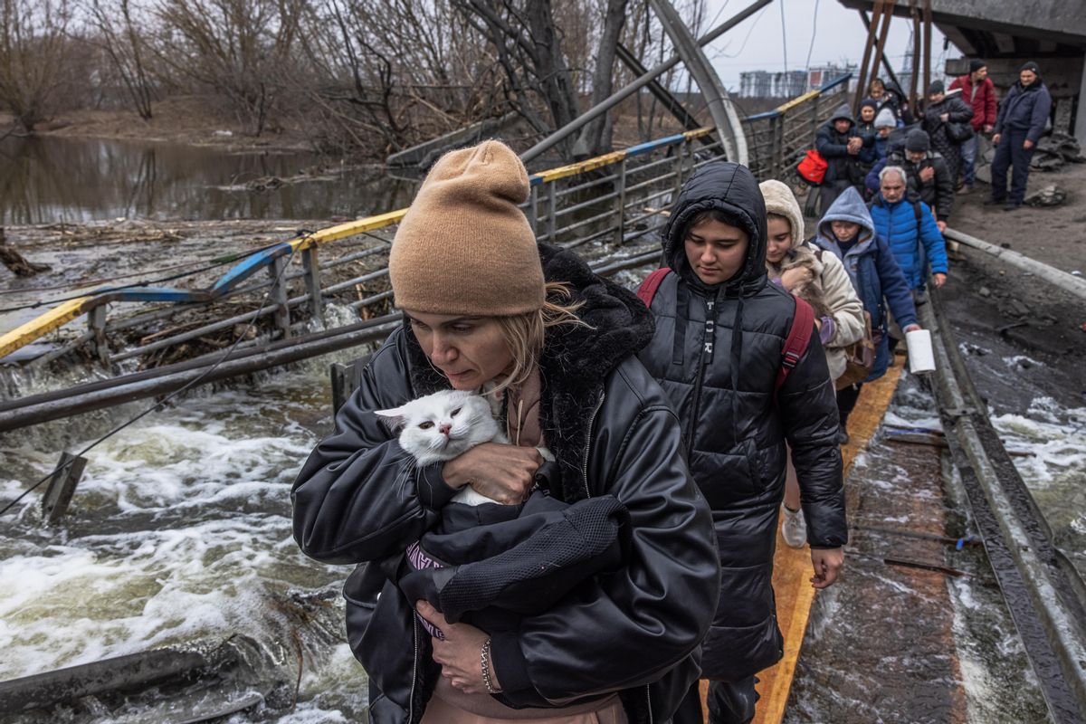 Varias mujeres cruzan un puente destruido en Irpin.