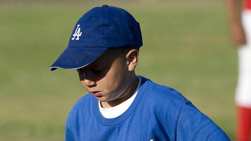 Juan Guizar Jr., de 9 años, practica con el bate de béisbol en el parque Martin Luther King del sur de Los Ángeles, California (EEUU).