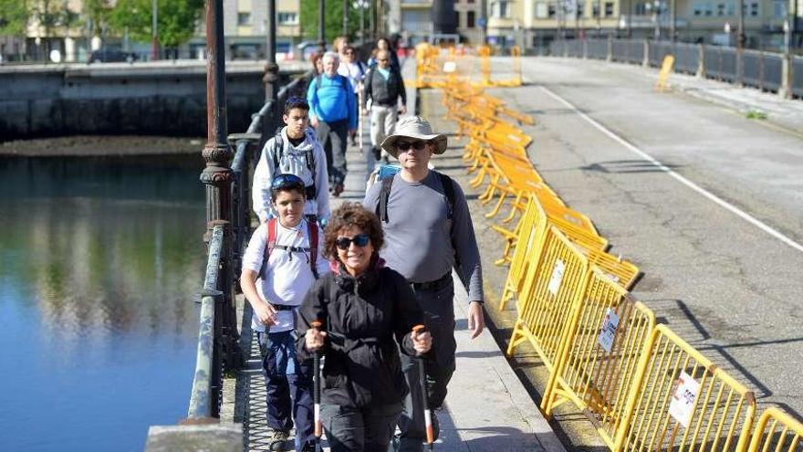 Un grupo de peregrinos cruzaba ayer el puente de O Burgo, en plena rehabilitación. // G. Santos