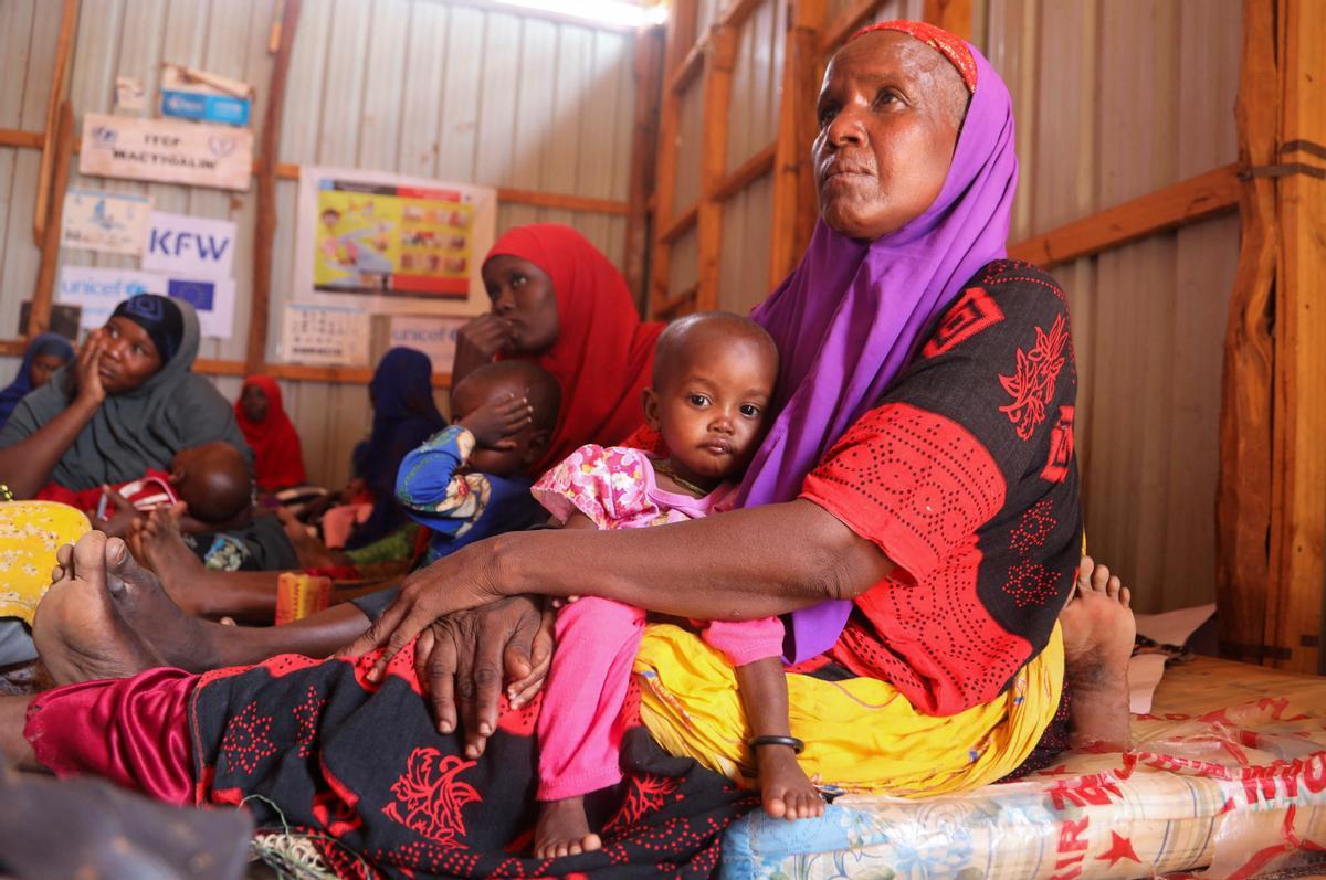 Mujeres somalíes desplazadas internamente sostienen a sus hijos mientras esperan la detección de desnutrición en el hospital.