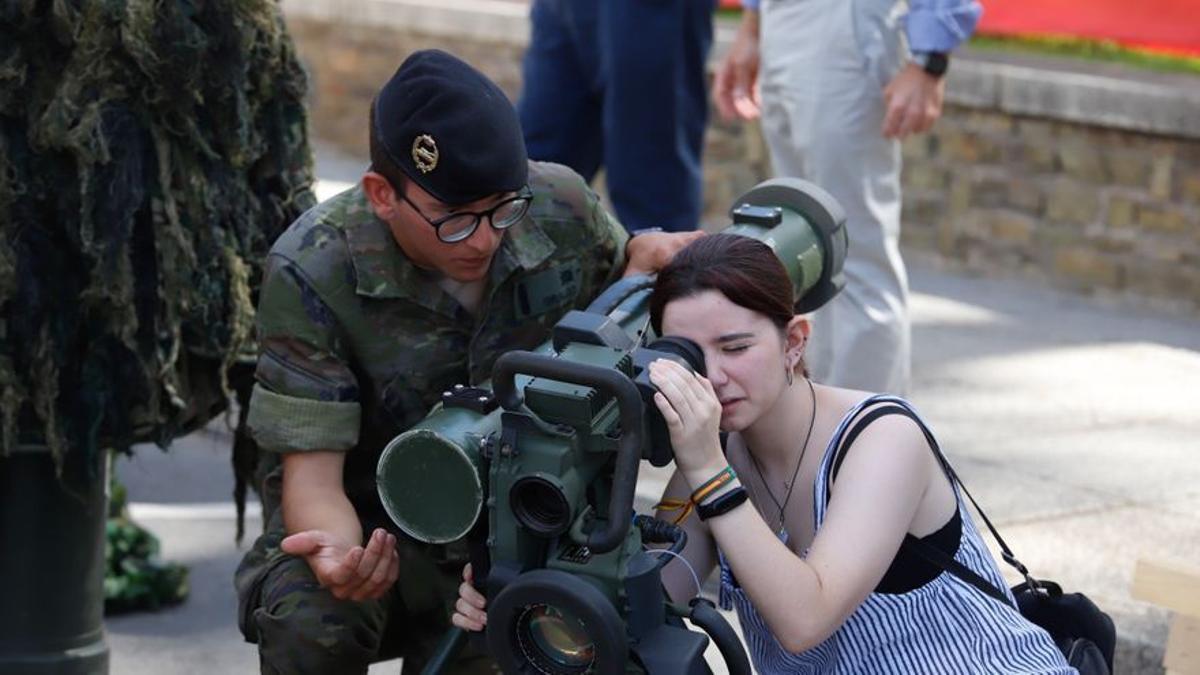 Una joven mira a través del visor de un lanzamisiles Spike en la exposición de vehículos de combate de la Jornada OTAN para jóvenes.