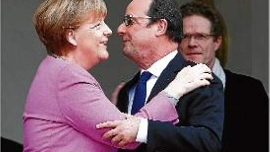 Merkel i Hollande se saluden abans de l&#039;inici de la seva reunió.