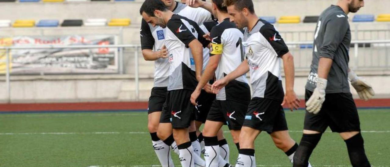 Los jugadores del Caudal celebran un tanto marcado al Llanes con el meta llanisco, Gabri, al lado.