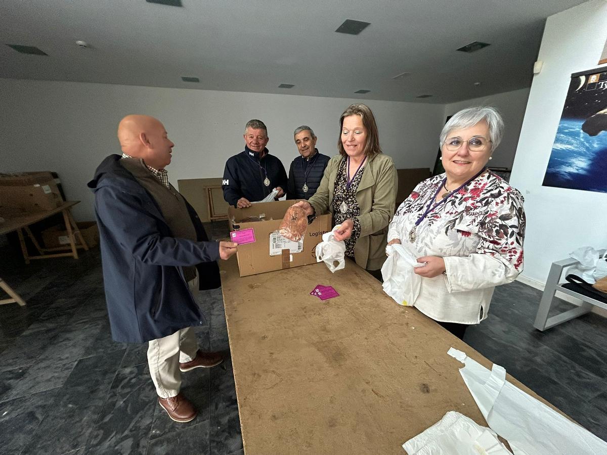 Un cofrade recoge uno de los bollos listos para la entrega tras la Vigilia Pascual.