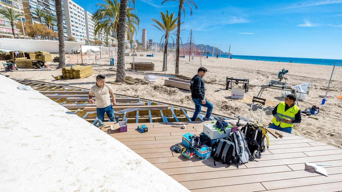 Los operarios colocan los primeros listones de la nueva madera tecnológica en Benidorm.