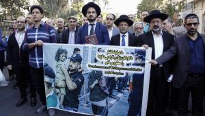 Miembros de la comunidad judía iraní exhiben una pancarta, durante una manifestación antiisraelí para condenar el ataque de Israel a Gaza.