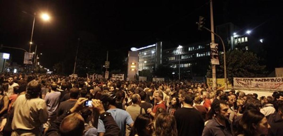 Empleats de la radiotelevisió pública grega concentrats davant la seu de l’ens, aquest dimarts a la nit a Atenes.