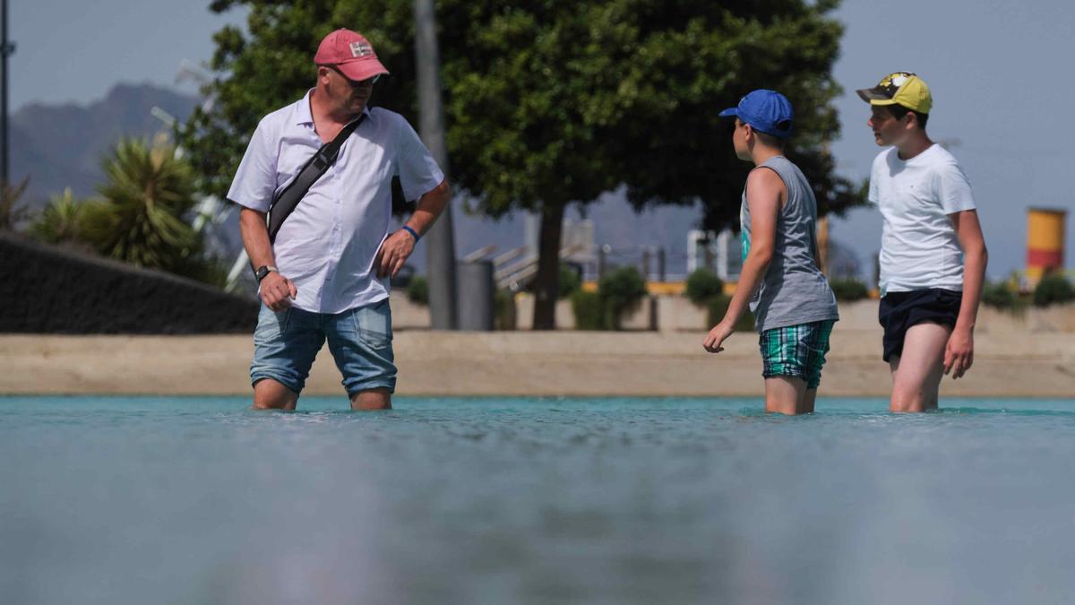 Varias personas huyen del calor en la charca de la Plaza España, Santa Cruz.