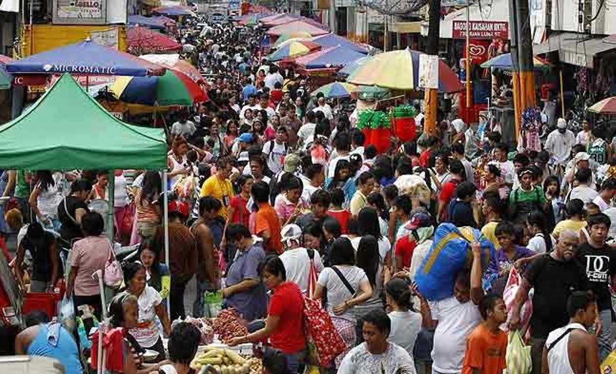Compradors filipins passegen al llarg d’un carrer del mercat Divisòria de Manila (Filipines).