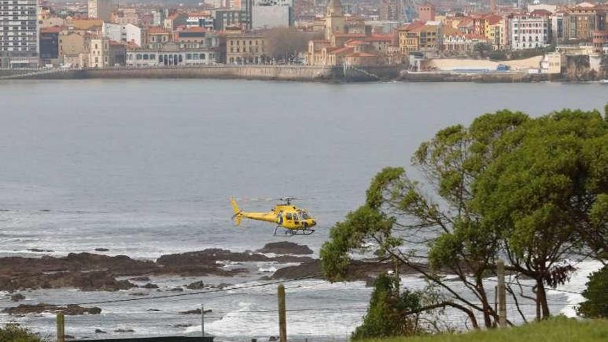 Un helicóptero de Bomberos de Asturias peinando las rocas.