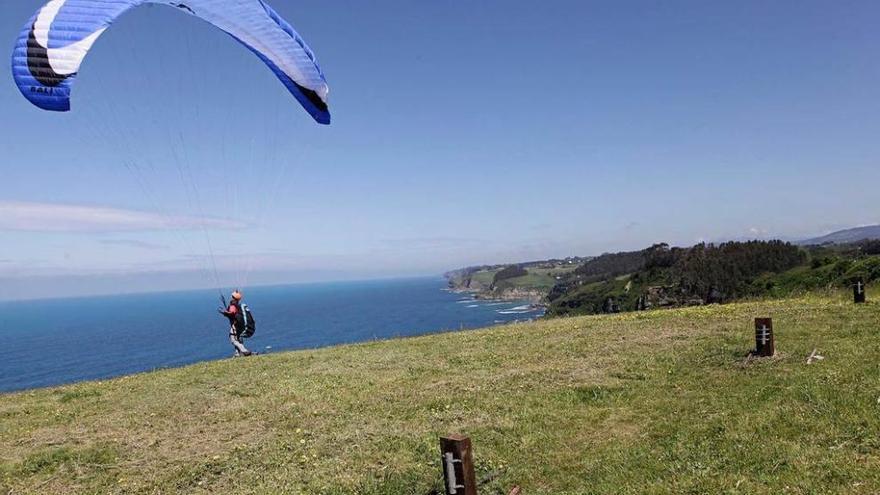 Un piloto dispuesto a lanzarse en parapende desde la zona de despegue de la Colina del Cuervo. En primer término, los postes del cierre, abiertos en ese momento.