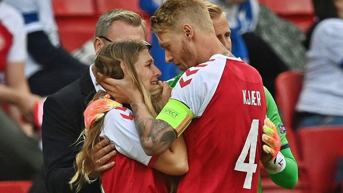 Kjaer, capitán danés, trata de consolar a la novia de Eriksen que saltó al campo. |  // REUTERS 