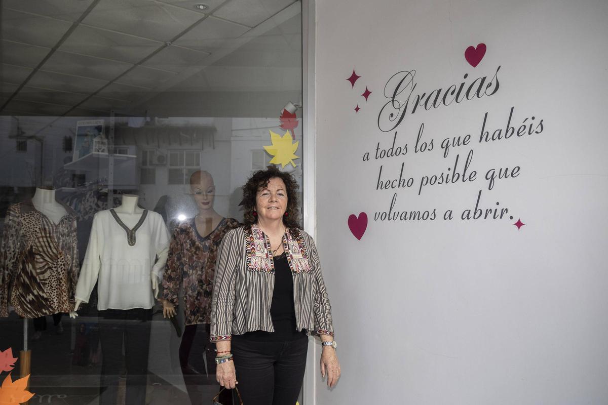 Mercedes Dávila junto al letrero dedicado a todas las personas que le han ayudado para volver a abrir el negocio.